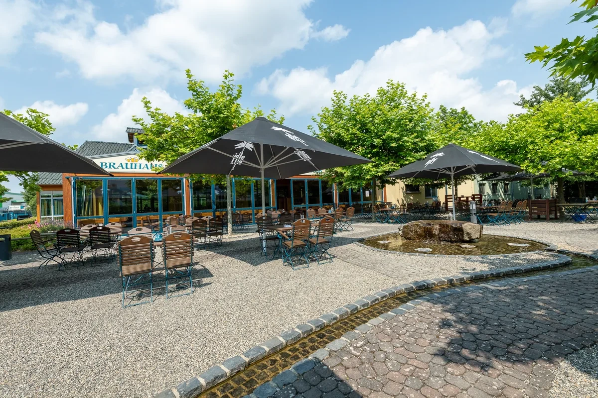 Biergarten des Brauhauses 1880 mit Sonnenschirmen und Brunnen