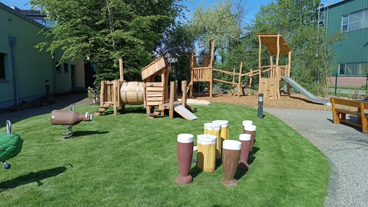 Spielplatz mit Holzspielgeräten, Rutschen und Kletterelementen